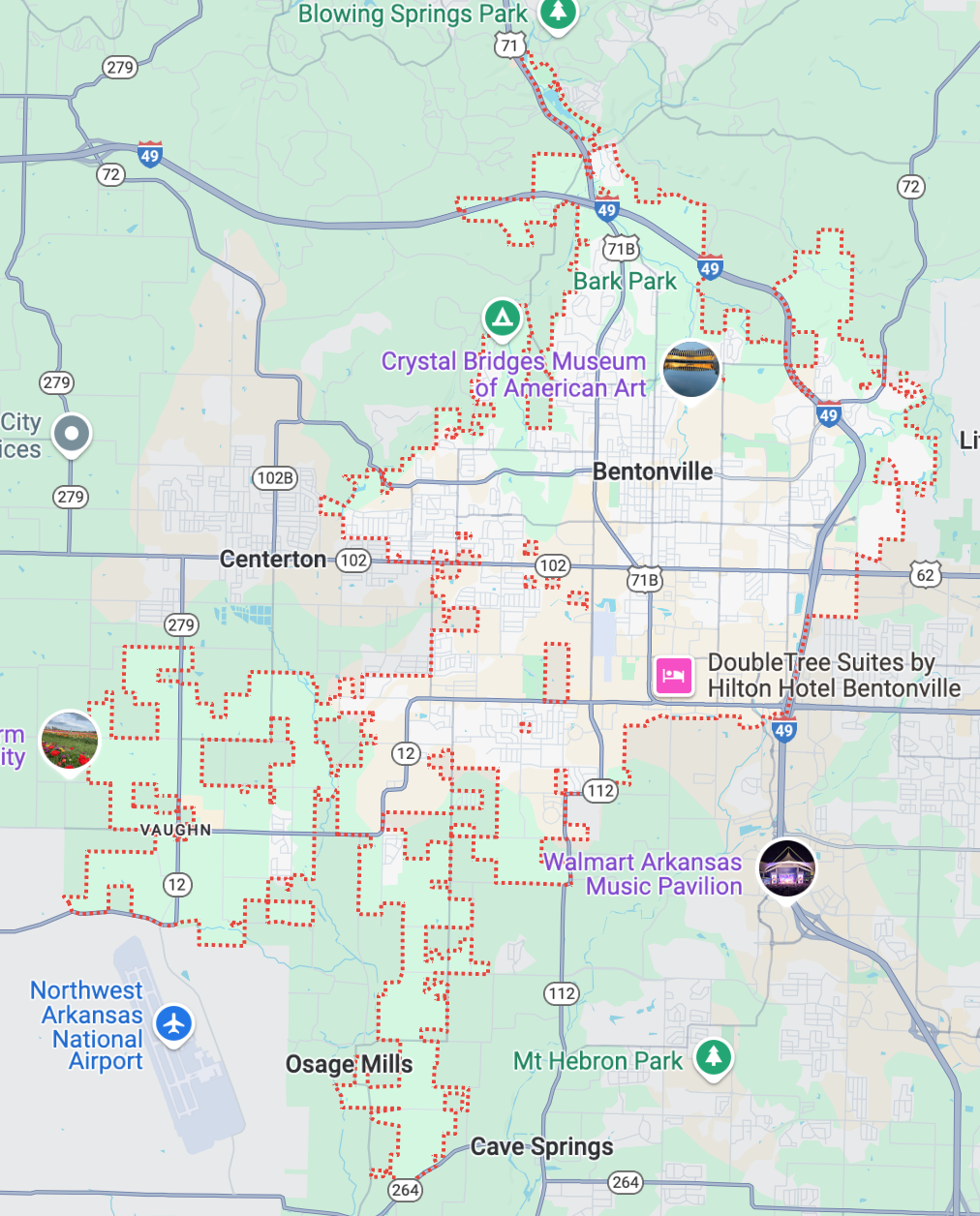 Map showing Bentonville, Arkansas, with labels for local attractions and city boundaries marked in red dashed lines. Nearby cities, roads, and parks are also visible.